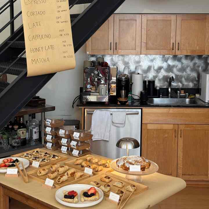 Light brown wood tone kitchen space with coffee machine and assorted pastries showcased in a cozy home cafe style setting