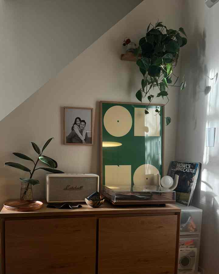 White-toned living room featuring a brown wooden cabinet topped with a white Marshall speaker and turntable against decorated walls