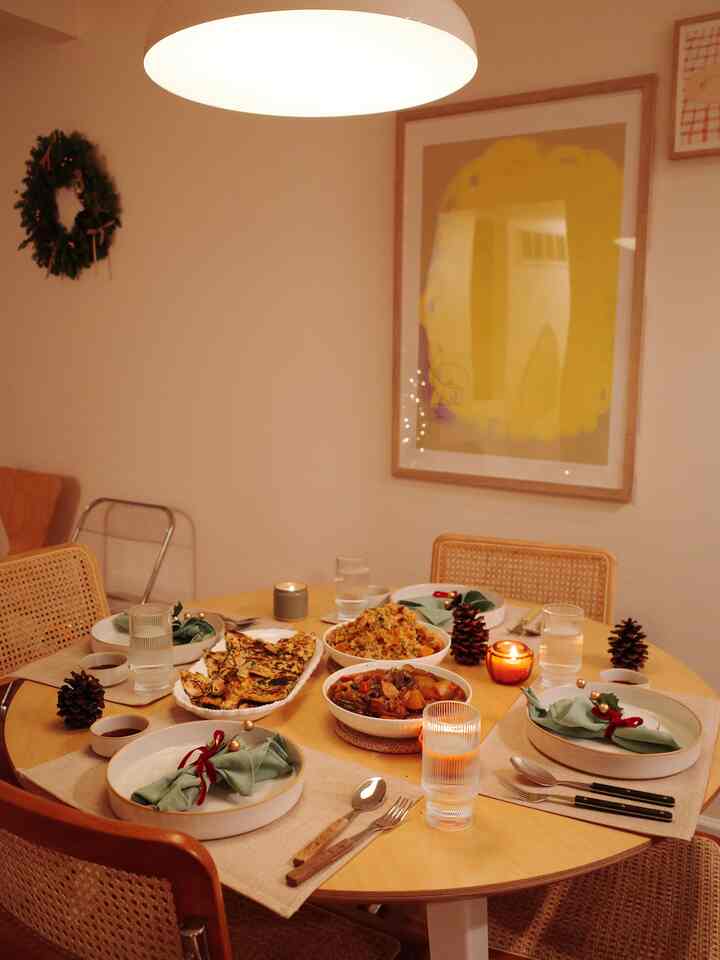 Natural wood tone and beige dining room decorated with Christmas wreath and candles for cozy home party