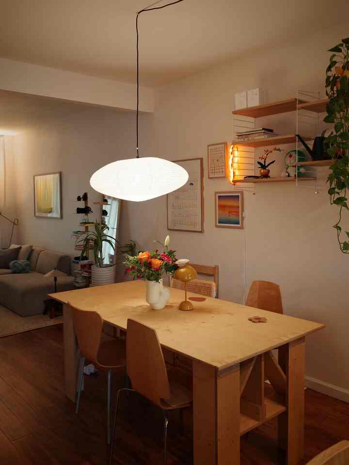 Natural toned dining room featuring mid-sized wooden dining table and chairs, pendant light creating cozy ambiance