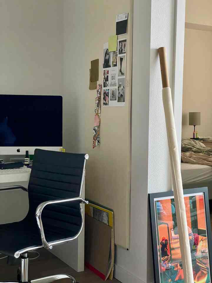 Natural-toned home office featuring a white desk, black office chair, and a colorful framed artwork by the wall
