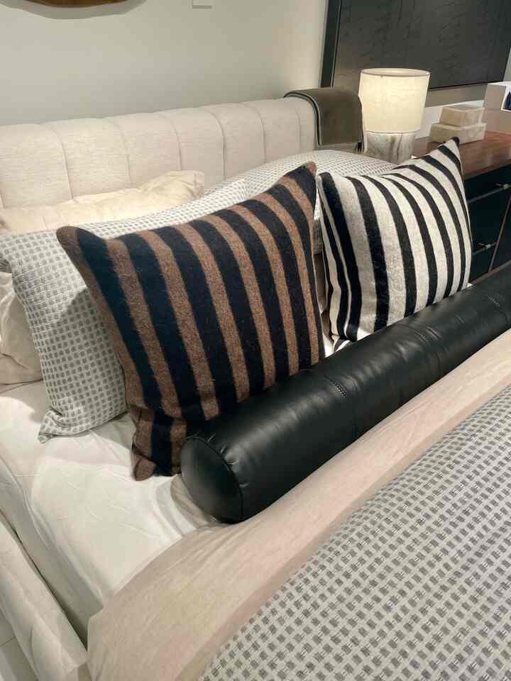 Love placing multiple pillows on a bed. It adds more dimension and can allow for more texture in your bedroom. #pillows #bedroom #stripes