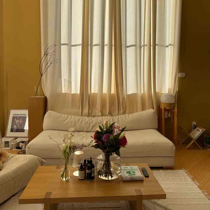Warm beige and wood-tone living room featuring a beige sofa and wooden coffee table with a natural modern atmosphere