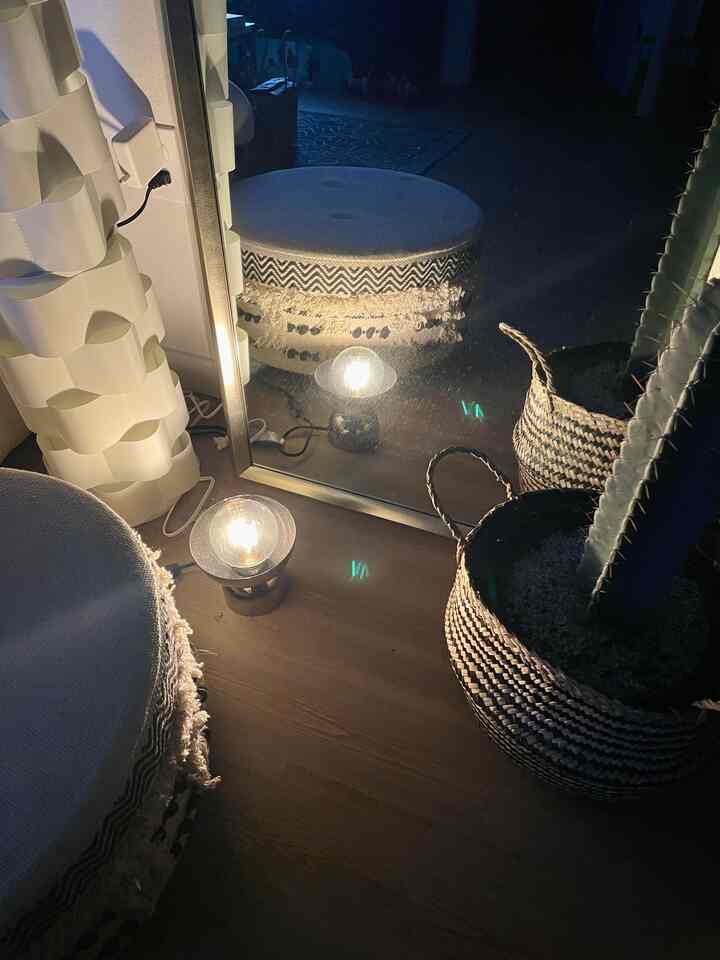 Warm brown-toned corner space featuring rattan baskets and soft lighting creating a cozy interior