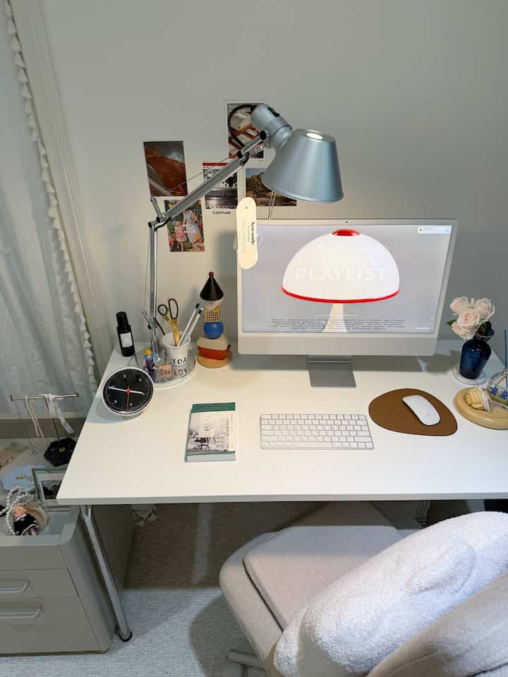 White and beige toned home office space featuring a Mid-Century Modern desk and Artemide lamp in a clean work setup
