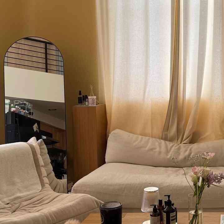 Beige and wood tone living room featuring cozy sofa and recliner chair with warm, inviting atmosphere