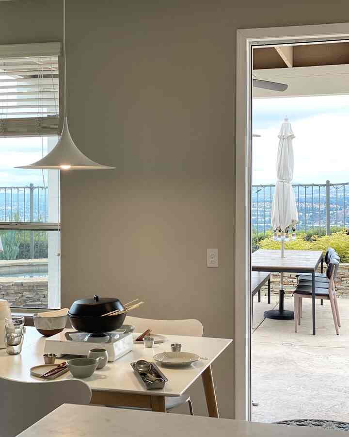 White and brown toned dining room featuring pendant light and cooking utensils on table, creating a cozy space