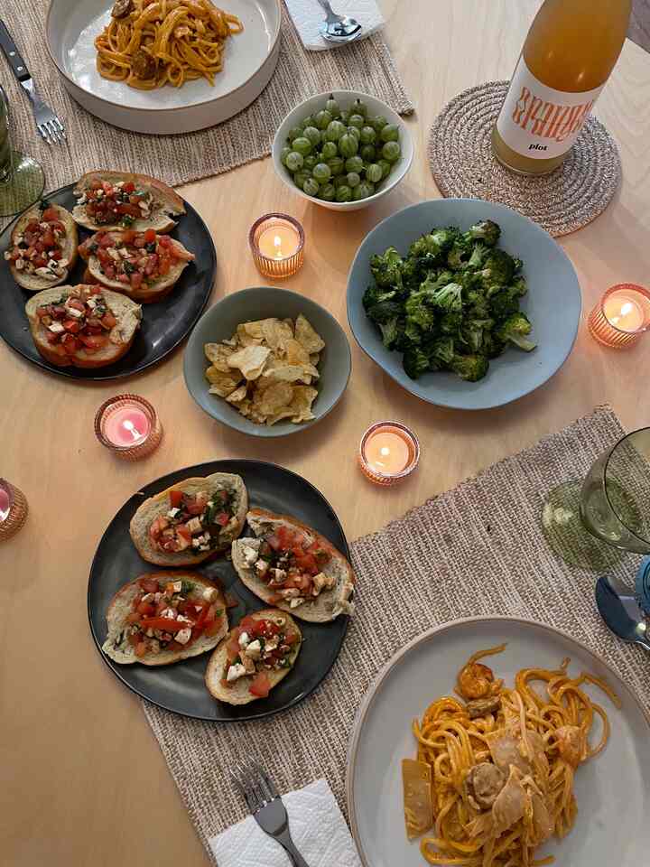 Beige-toned dining room featuring a table with assorted food and candles in a cozy atmosphere