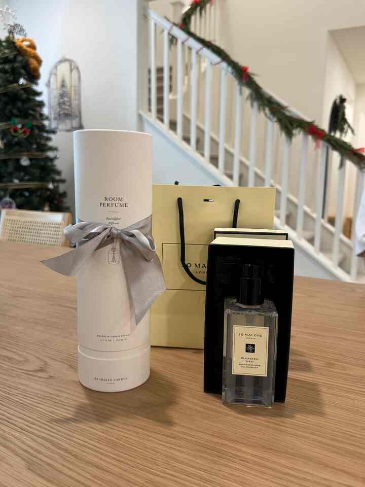 Modern living room with white and black tones featuring a diffuser and hand wash on a wooden dining table