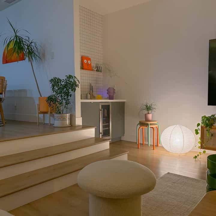 Natural-toned living room featuring wooden floor, stools and a rice paper floor lamp creating a cozy atmosphere