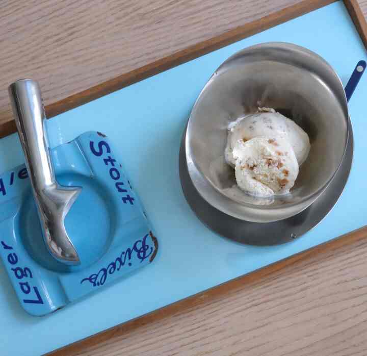 Blue and wood-tone tray holding a vintage-style metal bowl with ice cream in a minimalistic setting