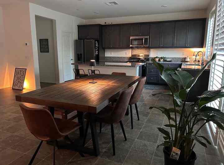Brown wood dining table and chairs in black kitchen and dining room, creating a cozy modern space