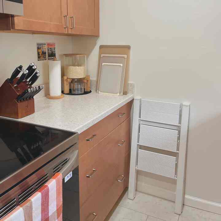 Beige wood-tone kitchen featuring knife set block and bamboo rice dispenser with simple, clean layout