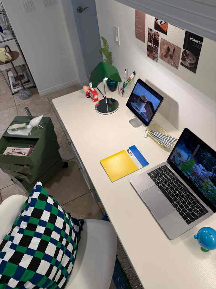 White and green toned home office featuring a clean desk with digital devices, creating a modern workspace atmosphere