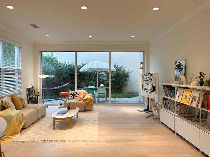 White and beige toned living room featuring beige sofa and coffee table with a comfortable, natural atmosphere
