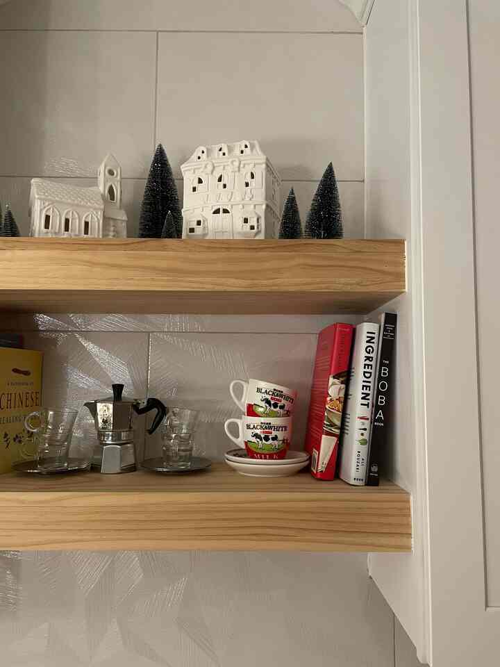 Beige-toned walls and wood tone shelves in kitchen space, featuring coffee items and decor in a natural modern style
