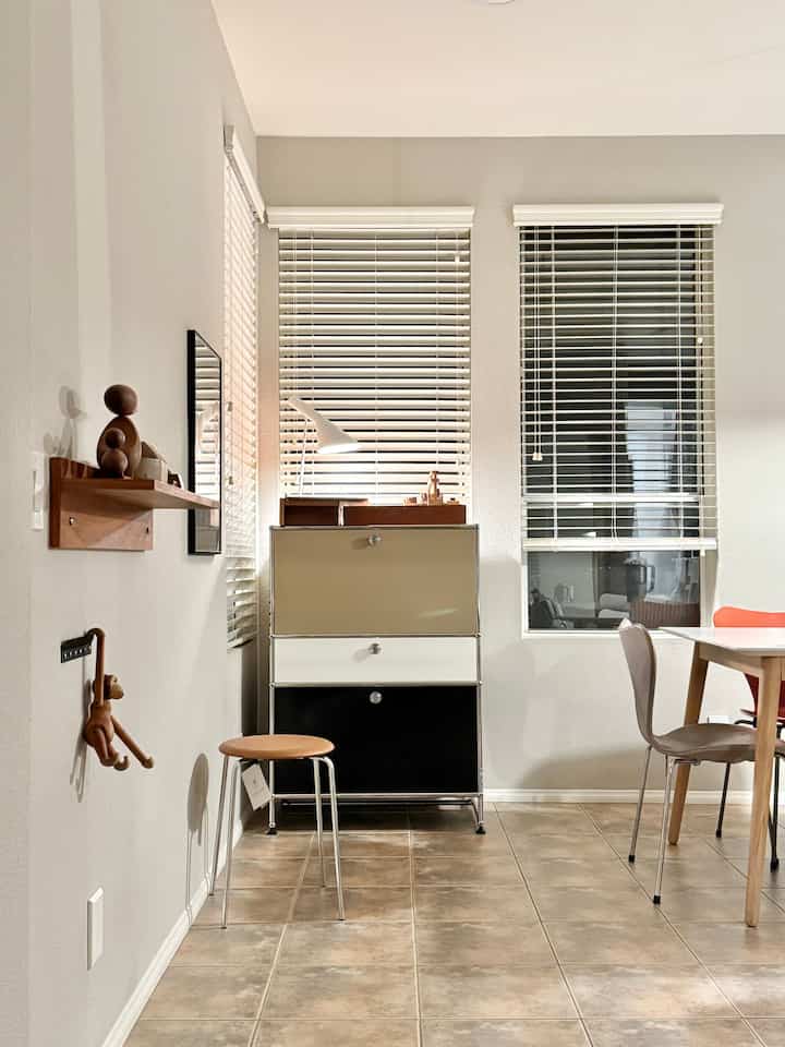 Modern dining room in brown and white tones, featuring USM Haller storage, dot stool, and minimalist neat layout