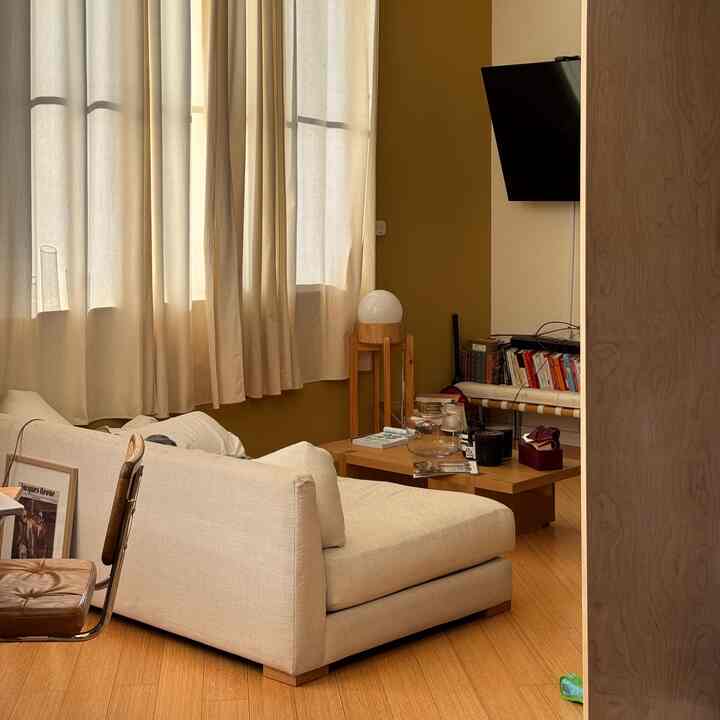 Natural color wood-tone loft living room featuring white sofa and coffee table with cozy, minimalist atmosphere