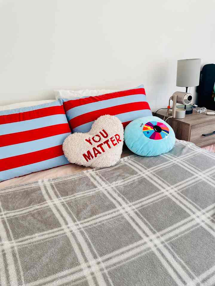 Some color and prints in my bedroom! Love the subtle pops and conversation pillow. #heartpillow #stripes #patterns #bedroomdecor 