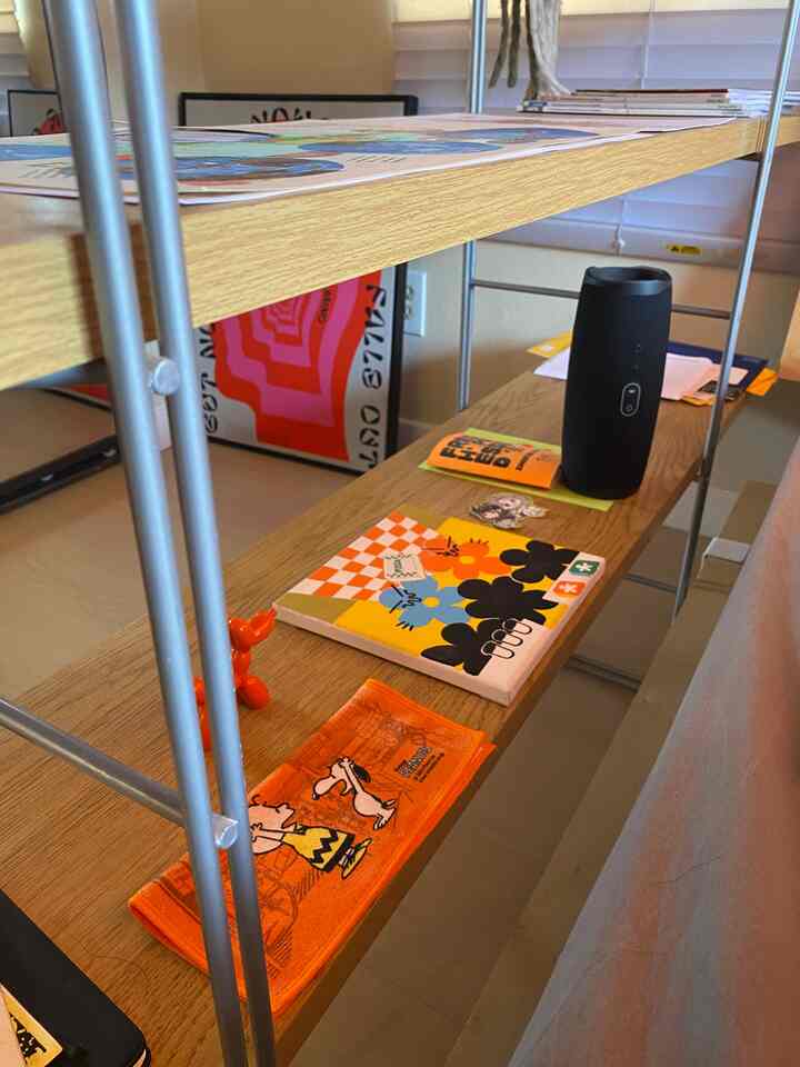 Natural brown-toned shelf displaying various objets and books in a tidy setting
