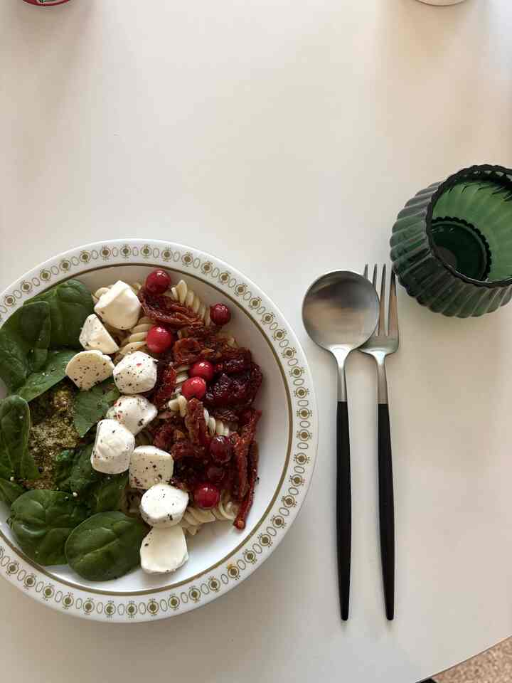 Clean brunch setting on a white table featuring Italian pasta and cutlery with black handles