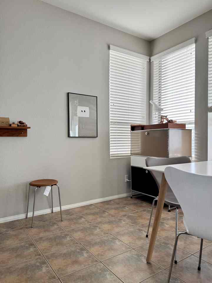 White and brown-toned dining room featuring a minimalist picture frame and modular storage unit with a modern cozy atmosphere