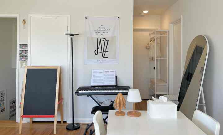 White and beige toned living room featuring keyboard and table lamps with a simple and warm atmosphere