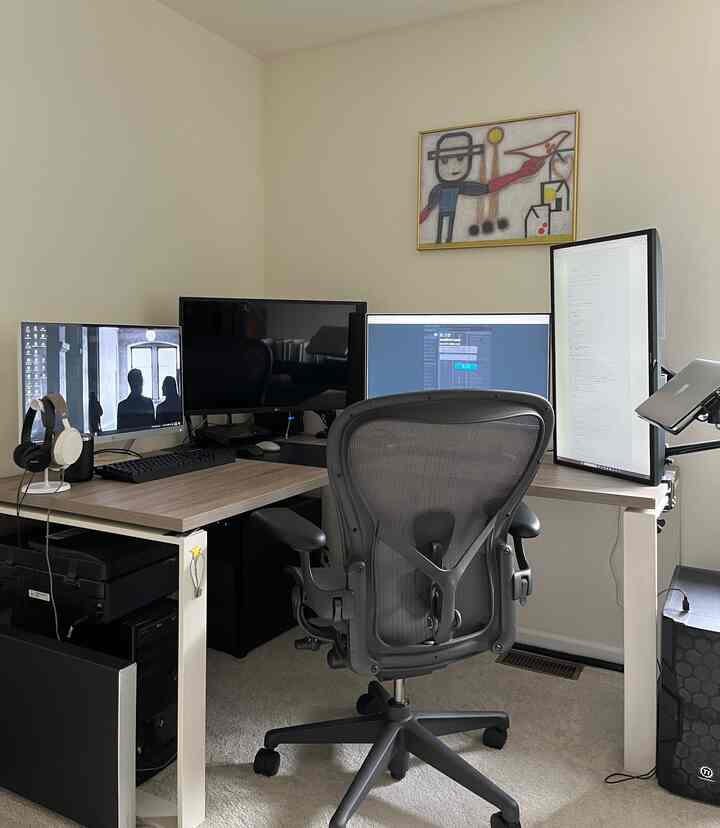 Gray-toned home office with an Aeron chair and four monitors arranged for a functional workspace