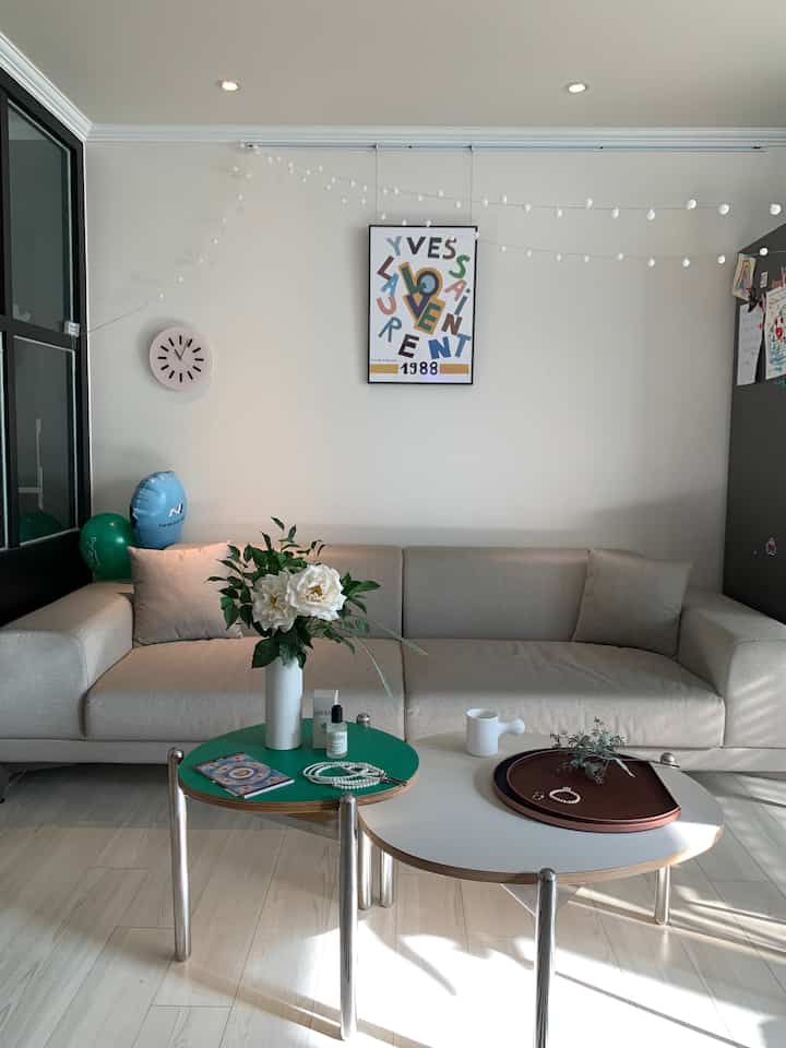 Natural color toned living room featuring beige sectional sofa and round coffee tables with a simple and modern atmosphere