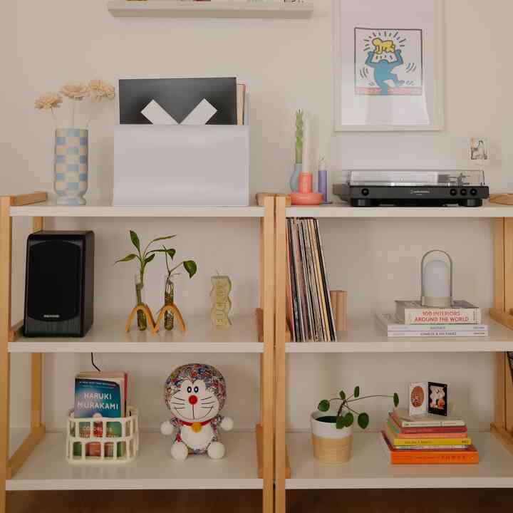 White and wood tone bookshelf featuring a retro-style audio player station with vinyl records and decorative items
