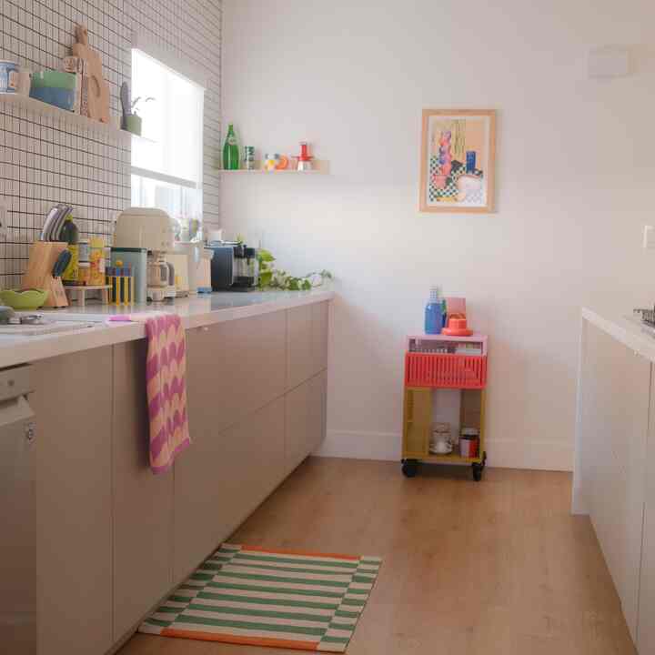 Bright natural color and wood tone kitchen featuring clean cabinetry, towels, and a storage cart, with a cozy atmosphere