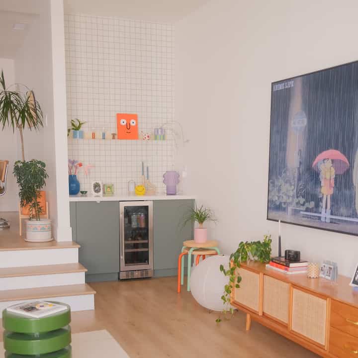 Natural toned living room featuring corner storage cabinet and various plants with warm, inviting atmosphere