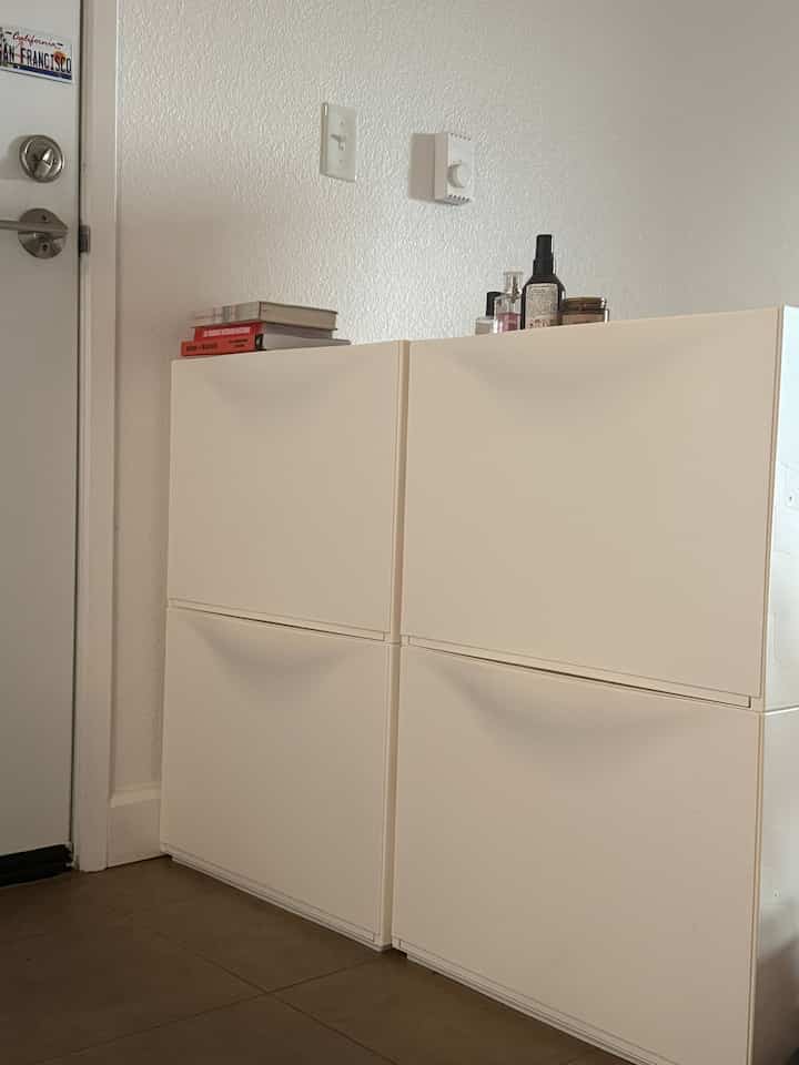 White-toned entrance featuring a neatly organized 4-compartment shoe cabinet with a simple atmosphere