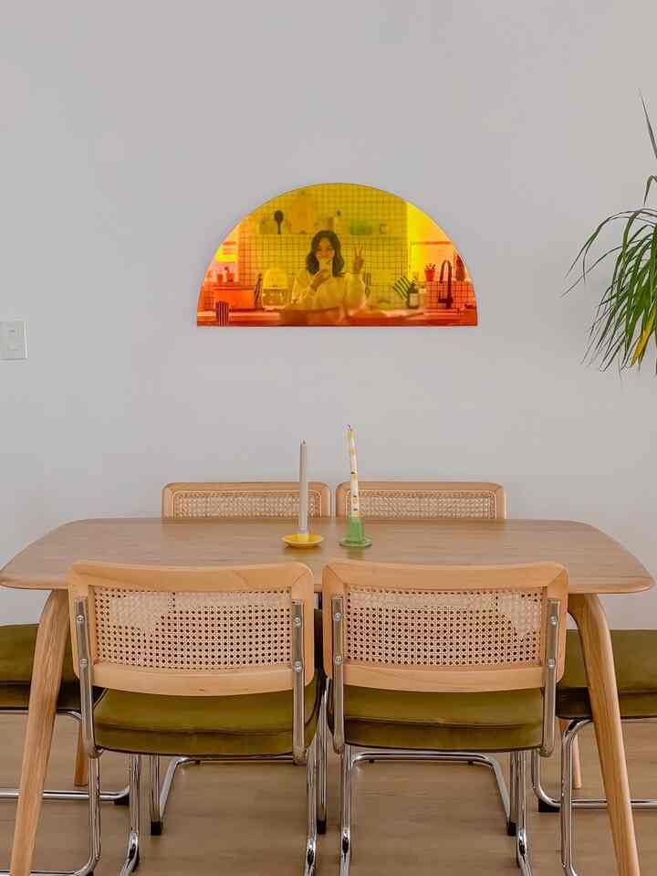 Natural wood-toned dining table and chairs arranged in a clean, warm 4-person dining room space