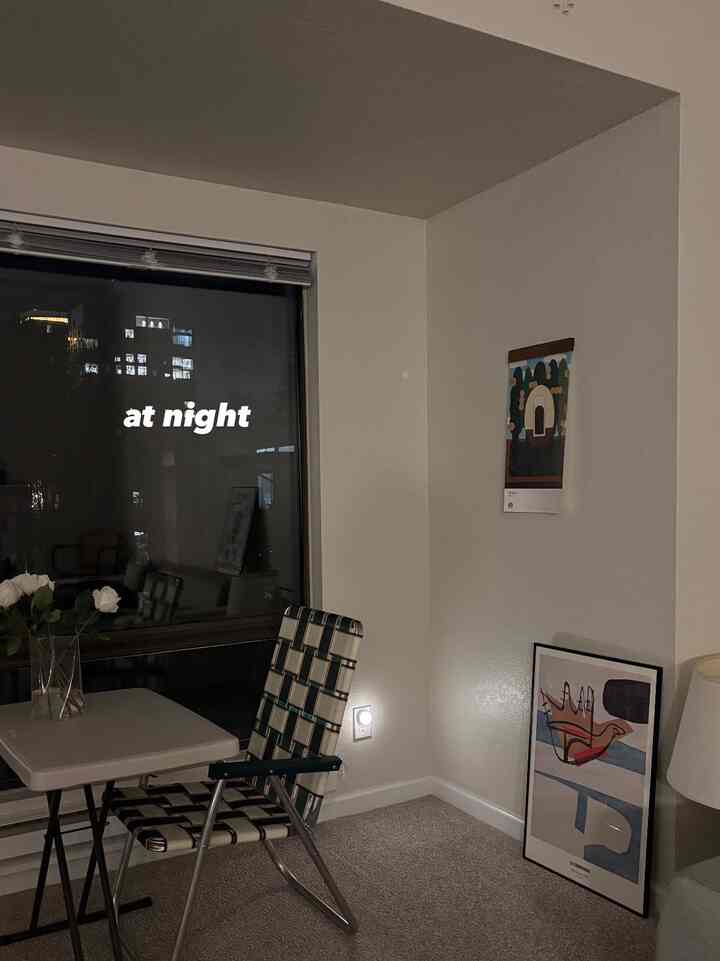 Compact room with beige carpet and white walls featuring folding outdoor chair and table in simple interior