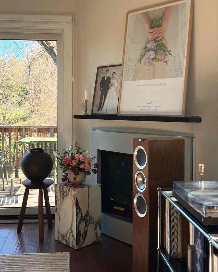 Natural tone living room featuring wood tone furniture and a vase on marble plinth, creating a cozy atmosphere