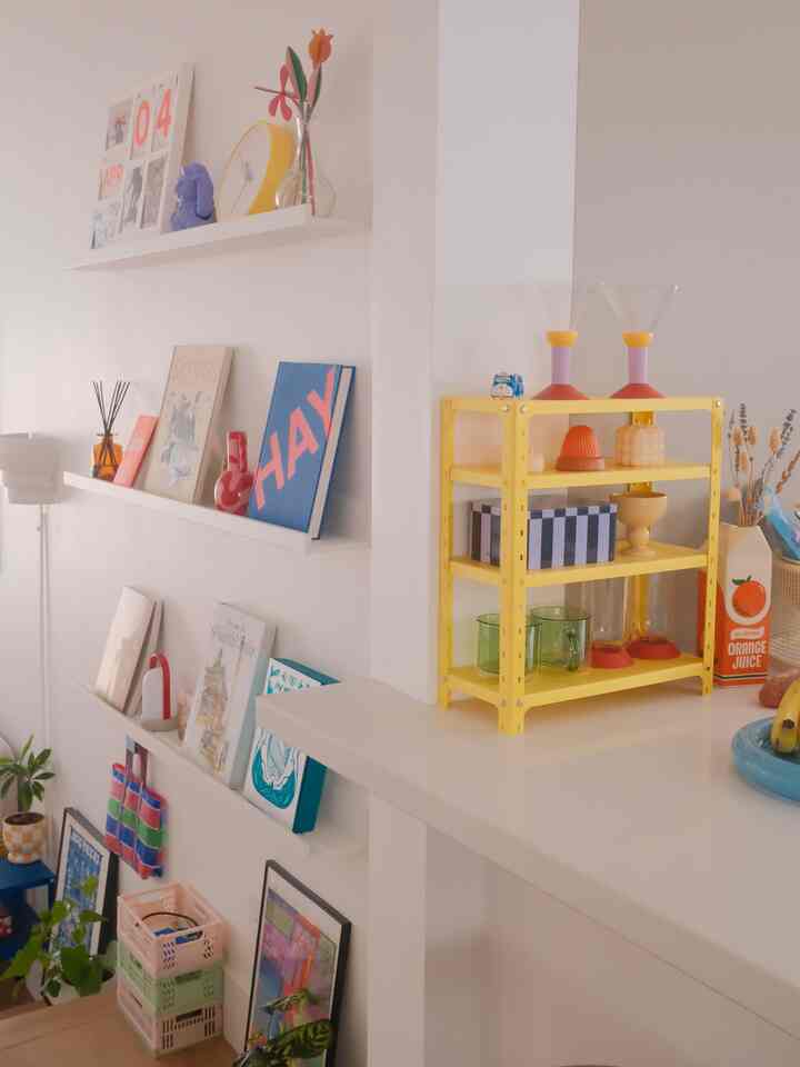 Modern entrance space in yellow and white tones featuring wall shelves and a yellow storage rack with a clean, instagrammable interior