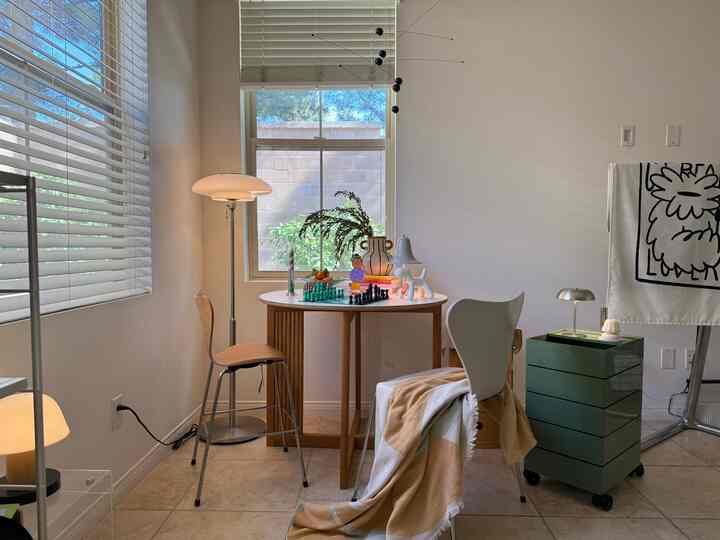 A bright beige and wood-tone Mid-Century Modern living room featuring a chess set on the table and various lamps creating a cozy atmosphere