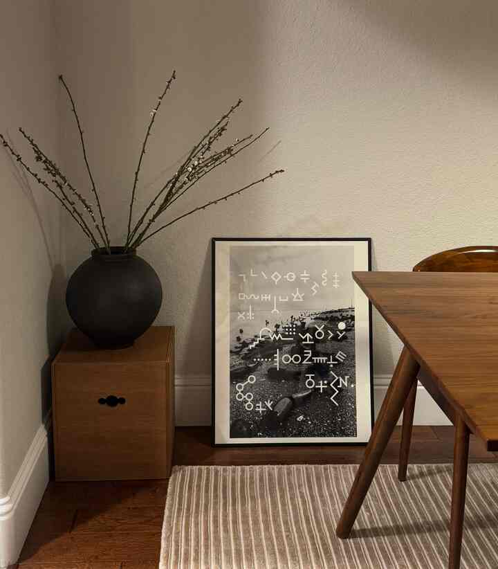 Beige-toned wall corner dining room featuring wood tone dining table and framed art, creating a modern and cozy atmosphere
