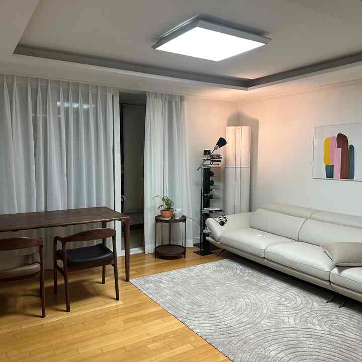 White and brown wood tone living room featuring dining table and sofa with a simple, natural atmosphere