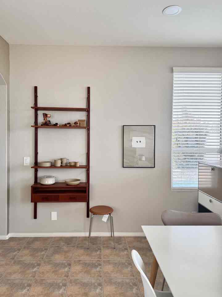 Natural tone dining room with light beige walls and brown wooden wall-mounted shelf