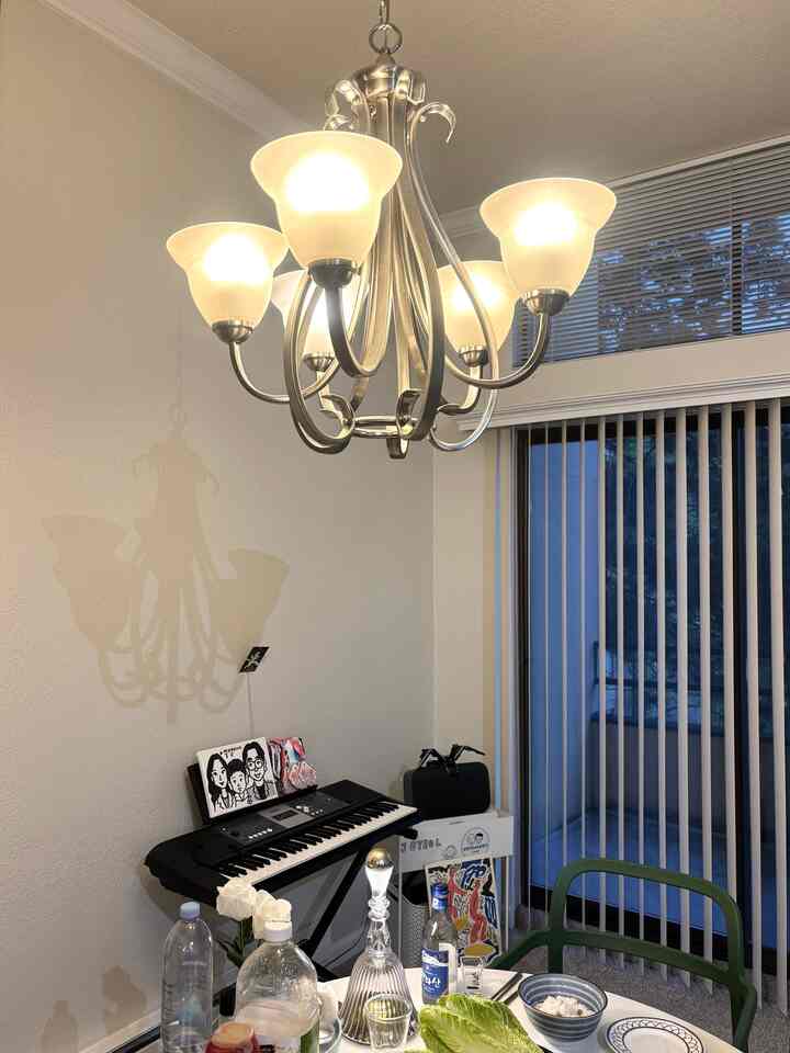 A white and silver toned dining room featuring an electronic keyboard and dining table set for dinner