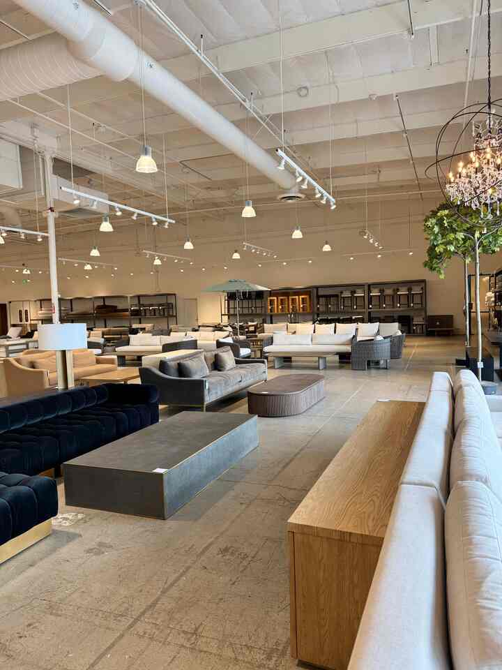 Spacious showroom living room in natural colors and wood tones, featuring modern sofas and coffee tables with a luxurious atmosphere