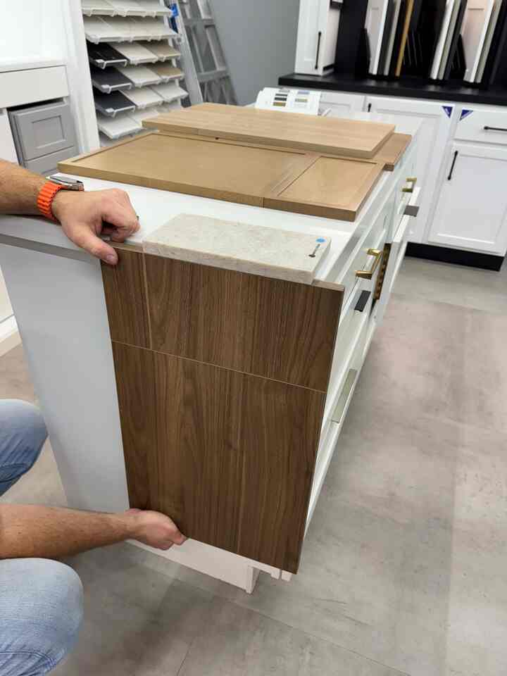 Interior materials space featuring brown wood samples and white cabinet panels