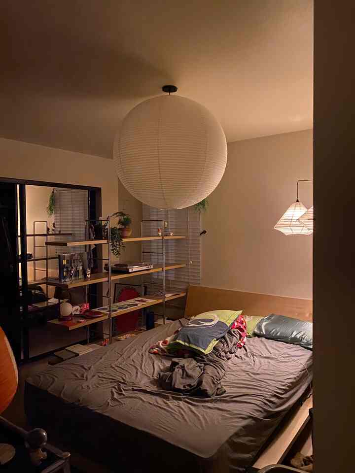 Warm-toned bedroom featuring natural wood bed frame and gray bedding with a cozy atmosphere