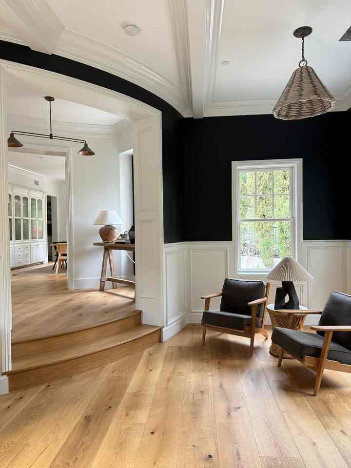 White and black toned living room with wood flooring and armchairs, creating a natural and modern atmosphere