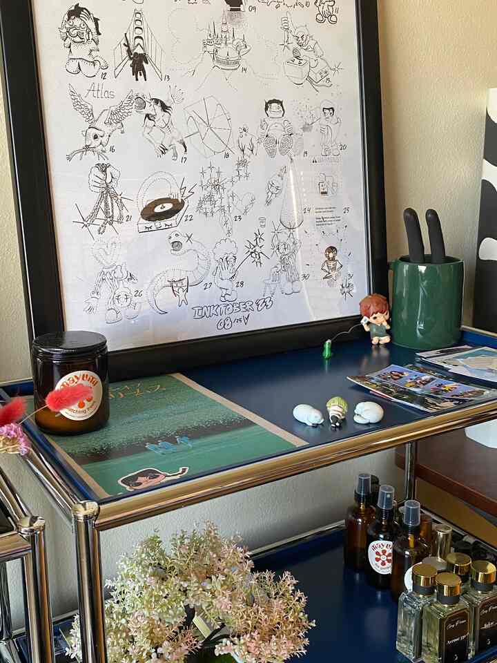 Cozy space featuring blue and silver-toned storage shelf with candles and interior decor items