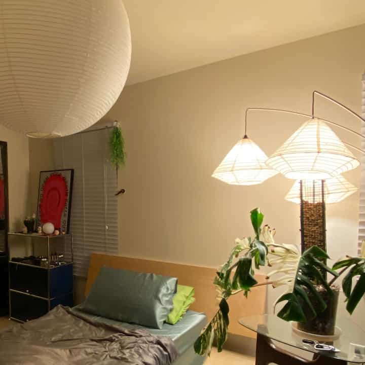 Beige and wood tone bedroom featuring mid-century modern nightstand and floor lamp in a cozy Japandi style