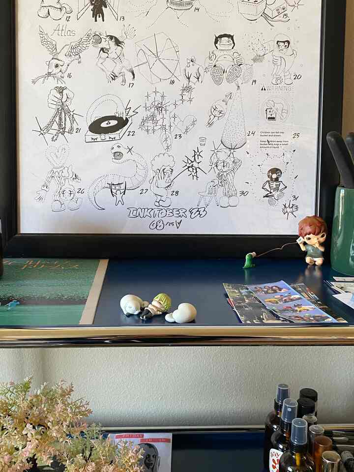 Mid-century modern home office with various objets and framed art on a blue cabinet