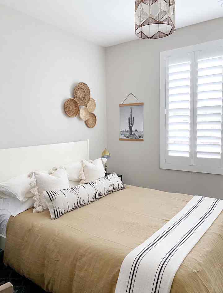 Natural color tone beige bedroom featuring woven wall basket decor and cozy cushions creating a warm atmosphere